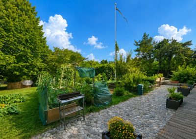 Le potager de la maison : carrés surélevés, allée de galets et bacs fleuris