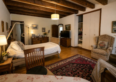 Chambre Érables : le lit, la télévision et le fauteuil