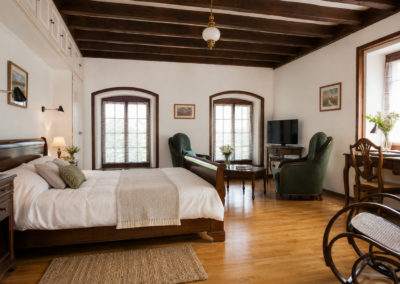 Chambre Oliviers : la chambre sous les poutres, lit et coin salon